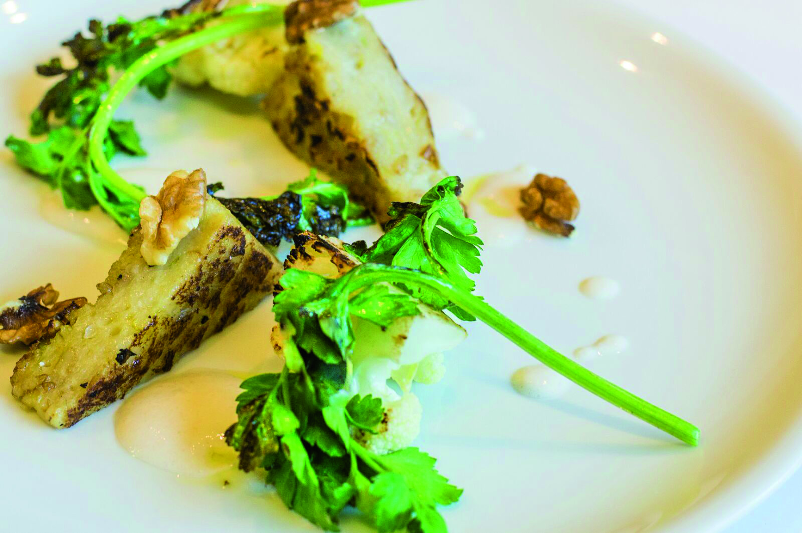 Flan di cavolfiore e avena con noci e latte di mandorle frittelle di cavolfiore e fiocchi davena cotte in padella lionese gocce di latte di mandorle leggermente affumicato e noci
